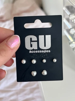 Tre par söta pärlörhängen från GU Accessories - Säljer ett set med tre par pärlörhängen från GU Accessories💟 Örhängena är vita och finns i både rund och hjärtformad design. Perfekta för att mixa och matcha till söta outfits! Klassiskt och stilren accessoar som passar till alla tillfällen! Har aldrig använt‼️