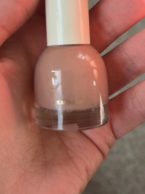 Nude nagellack från H&M - Snyggt nude-färgat nagellack från H&M i en rund glasflaska med vit kork. Perfekt för en naturlig look och passar till alla tillfällen. Lätt att applicera tack vare den smidiga borsten och ger en jämn finish.