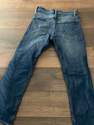 Blå raka jeans från Levi's - Klassiska blå jeans från Levi's med raka ben och femficksmodell. Jeansen har snygga slitningar och kontrastsömmar, samt Levi's ikoniska bakfickor med V-formad söm. Tillverkade i slitstark denim, perfekta för en avslappnad stil.