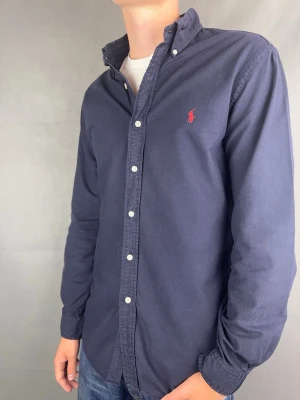 Ralph Lauren skjorta marinblå slimfit herr M - Ralph Lauren Skjorta slimfit marinblå  Märke: Polo Ralph Lauren Storlek: M Passform: Slimfit Färg: Mörkblå Skick: Mycket bra Beskrivning: utan defekter. Modellen på bilden: 183 cm / 74 kg