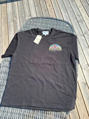 Svart t-shirt från Casablanca - Snygg svart t-shirt från Casablanca med färgglad broderad logga och motiv på bröstet. Klassisk passform och rund halsringning. Tillverkad i mjuk bomull som känns skön mot huden. Perfekt för dig som vill ha en stilren men ändå unik look.