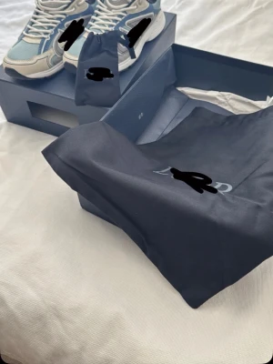 Blå och vita chunky sneakers - Snygga chunky sneakers i blått, vitt och grått med detaljer i beige. Skorna har en modern och sportig design med tjock sula och meshpaneler för extra komfort. Perfekta för dig som vill ha en trendig och bekväm look. Helt oanvända o allt medföljer 
