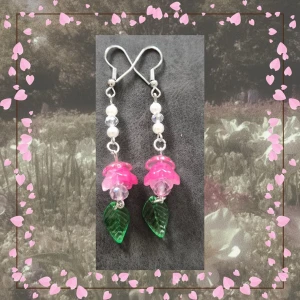 Örhängen – Blooming Bell – Rosa, Grön & Silver - 🌸🩷 Flower Fairycore- & Bloomcore-inspirerade örhängen i rosa, grönt och silver med blomma, blad och dinglande detaljer. ✨  Längd ca 7cm (Bild 3)  Handgjort av mig  Frågor? Skicka bara. Kolla noggrant innan köp. Klicka in på fotona. Returer av smycken godkänns ej av hygienskäl.