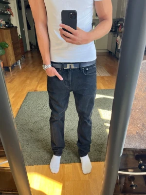 Svarta jeans - Säljer ett par svarta jeans med rak passform och klassisk femficksdesign. Jeansen har normal midja och är tillverkade i ett mjukt denimtyg. Passar perfekt till en avslappnad stil och är lätta att matcha med olika plagg.