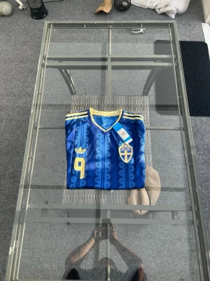 Sverigetröja Alexander Isak #9 🇸🇪 - Säljer en riktigt snygg Sverigetröja med Alexander Isak #9 på ryggen! ⚽️ Tröjan är helt ny och oanvänd. Den har en skön passform och snygg blå design med gula detaljer, vilket gör den perfekt för både matchdagen eller som en fet detalj till outfiten.  Storlek: M  Skick: Helt ny Skicka ett DM om du vill köpa eller har några frågor! 📩 