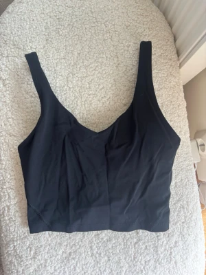 Svart sport-bh från Relode - Snygg svart sport-bh från Relode med breda axelband och längre modell. Tillverkad i ett stretchigt och mjukt material som ger bra stöd. Logga framtill i vitt. Perfekt för träning eller som bekväm vardags-bh.