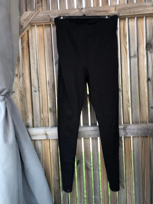 Svarta höga leggings - Snygga svarta leggings med hög midja och smal passform. De är stretchiga och mjuka, perfekta för en avslappnad look. Materialet ser ut att vara bomull eller bomullsblandning. Passar till allt och är superenkla att styla.