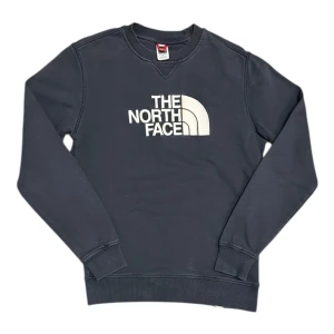The North Face Drew Peak Embroidered Logo Navy Sweatshirt - Den här varan kommer auktioneras ut på Sneakershyllan x Plick Live den Torsdagen 16 juli kl 19. Mörk diskret blå sweatshirt med broderad logga från The North Face. Storlek small, gott skick. 