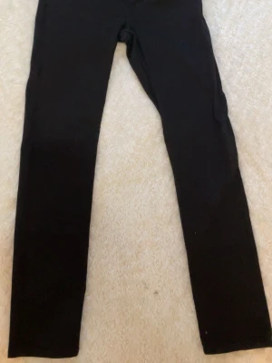 Svarta slim fit jeans - Säljer ett par svarta slim fit jeans med klassisk femficksdesign. Jeansen har en stilren look och är tillverkade i ett stretchigt material som ger skön passform. Perfekta till en avslappnad eller trendig outfit.