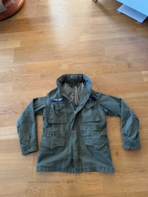 Ralph lauren army jacket - Säljer min Ralph lauren jacka då jag inte använder den längre, skicket är mycket bra då den är sparsamt använd. jag har lite svårt att tyda storlek men det finns bild på lappen på sista sidan, jag är 185 och väger 75kg och jackan sitter fint.