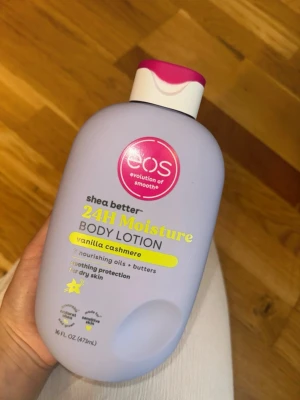 eos 24H Moisture Body Lotion Vanilla - eos shea better 24H Moisture Body Lotion i doften vanilla cashmere. Innehåller närande oljor och smör, ger långvarig återfuktning och silkeslen känsla. Ljuslila plastflaska med vit och rosa kork, 473 ml.