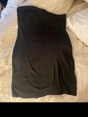 Svart oneshoulder klänning från Divided - Säljer en svart oneshoulder klänning från Divided. Klänningen är kort och har en tight passform som framhäver figuren. Perfekt för dig som gillar enkel men snygg stil. Materialet känns mjukt och stretchigt.