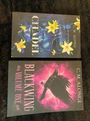 Citadel & Blackwing av C.M. Alongi - Två skönlitterära böcker av C.M. Alongi: 'Citadel' med ett mörkt omslag prytt av gula blommor och 'Blackwing Volume One' med en svart fågel mot en lila bakgrund. Perfekt för dig som gillar fantasy och spännande berättelser.