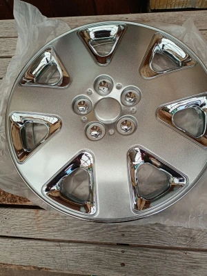 Snygg silverfärgad navkapsel 1 styck - En rund navkapsel i silver med fem trekantiga detaljer och kromade inslag. Tillverkad i plast och metall, passar de flesta standardhjul. Perfekt för att ge bilen ett fräscht utseende. Metallring för montering medföljer. 1 styck.