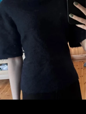 Marinblå stickad tshirt från Gina Tricot - Mysig marinblå stickad topp från Gina Tricot med korta ärmar och enkel, rak passform. Perfekt att styla med både jeans och kjol för en clean look. Materialet är en mjuk ullblandning som känns skönt mot huden. Som ny!🥰