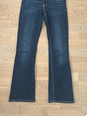 Mörkblå bootcut jeans med kontrastsömmar - Snygga mörkblå bootcut jeans med vita kontrastströmmar. Det finns inga hål eller defekter och har använts ett par gånger.                                                           Pris kan diskuteras 