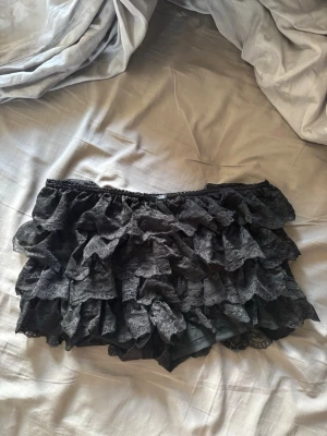 Svarta spetsvolang shorts - Säljer ett par svarta shorts med flera lager volanger i spets. 