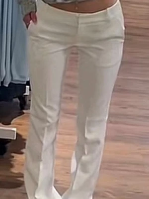 Vita  kostymbyxor Vera  - Snygga vita kostymbyxor med rak passform och hög midja. Byxorna har diskreta fickor bak och är tillverkade i ett slätt, vävt material som ger en clean look. Perfekta för dig som vill ha en stilren och modern outfit.