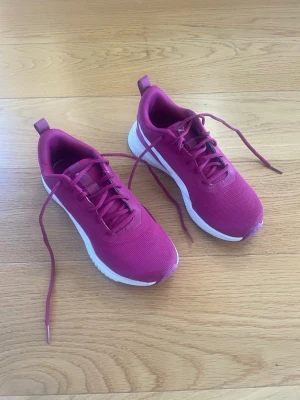 Lila inomhus skor från Puma - Snygga lila skor från Puma med matchande skosnören. Skorna har också en vit sula. Perfekta för träning inomhus eller till vardags.