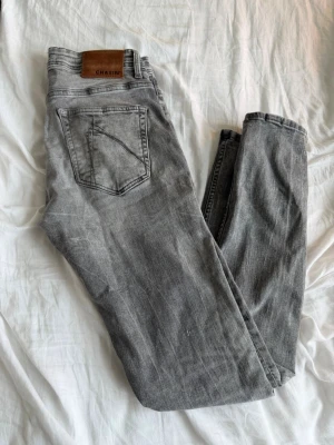 Chasin' jeans - Säljer ett par grå jeans från Chasin' med klassisk femficksmodell och raka ben. Jeansen har en snygg tvättad look och är tillverkade i bomull med en skön passform. Perfekta för en avslappnad och trendig stil.