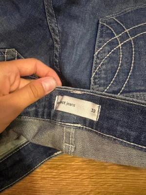 Blå jeans från Gina tricot, storlek 32 - Säljer ett par klassiska blå jeans från Gina i storlek 32. Jeansen har flared ben, fem fickor och coola kontrastsömmar på bakfickorna. Tillverkade i slitstarkt denim med en snygg tvättad look. Perfekta till sneakers eller boots.