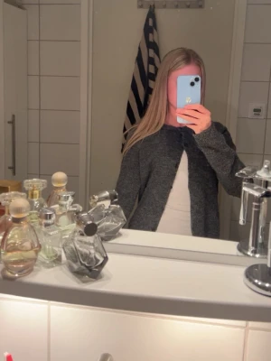 Mörkgrå kofta från H&M - Mysig mörkgrå kofta från H&M med rund halsringning och knäppning framtill. Koftan är använd flertal gånger men fortfarande i bra skick!