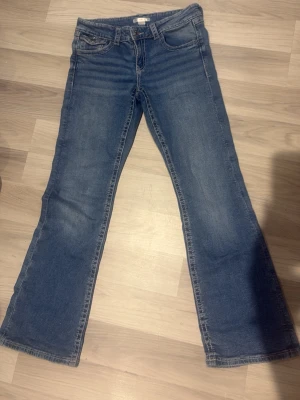 Gina y2k broderade jeans 💕 - Superfina och trendiga jeans från Gina Tricot i en perfekt mellanblå tvätt! Modellen har en jättesnygg bootcut/flare-passform och låg/medellåg midja som ger den rätta 2000-talslooken (Y2K). Det absolut bästa med jeansen är de otroligt snygga, broderade bakfickorna med lock och knappdetaljer – ger verkligen det där lilla extra! Märke: Gina Tricot Storlek: 158 (passar även utmärkt som en mindre XS beroende på hur man vill att de ska sitta) Modell: Bootcut / Flared Skick: Mycket gott skick! Skriv g