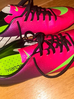 Nike mercurial vapor 9/IX GAMLA MERCURIAL - Säljer ett par Nike Mercurial fotbollsskor i en riktigt snygg rosa och grön färgkombination med svarta detaljer och snörning. Skorna har en lätt och smidig syntetisk ovandel samt dobbar för bra grepp på planen. Perfekta för dig som vill sticka ut på fotbollsplanen! I NÄSTAN OANVÖNT SKICK ps(pruttbart pris)