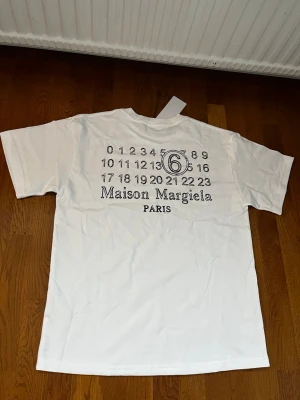 Maison Margiela T-Shirt Vit, S - Säljer denna t-shirt i storlek S, men skulle säga att den är stor i storleken och passar perfekt även för en M! 