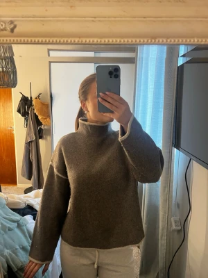Beige stickad tröja med hög krage från Zara - Säljer en beige stickad tröja från Zara med hög krage och breda ärmar. Den är trendig och även i väldigt bra skick