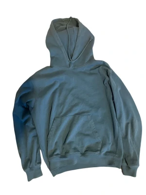 Blå hoodie från Stockholm Surfboard Club - Snygg blå hoodie med stor vit text på ryggen där det står 'Stockholm (Surfboard) Club'. Klassisk känguruficka framtill och huva. Perfekt för en avslappnad streetwear-look. Mjuk bomullskänsla och avslappnad passform.