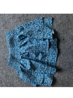 Blå blommig volangkjol - Supersöt blå kortkjol med mönster och volangdetaljer. Pris går att diskutera!