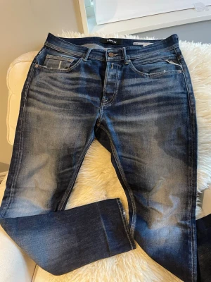 Mörkblå Replay Jeans - Jeans med en sällsynt fade och slitningar, modellen heter willbi och är regular slim fit