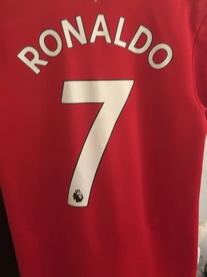 Manchester United Ronaldo matchtröja - Säljer en röd Manchester United matchtröja från Adidas med Ronaldo och nummer 7 på ryggen. Tröjan har klubbmärke, Adidas-logga och TeamViewer som sponsor framtill. Tillverkad i lätt och ventilerande material, perfekt för fotboll eller träning.