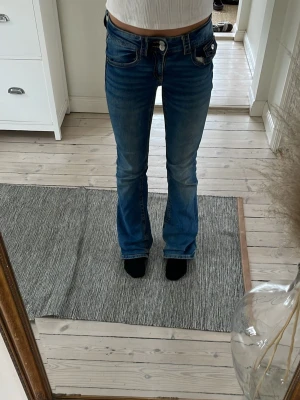 Blå bootcut jeans - Ett par blå lite slitna, snygga bootcut jeans. (Har lite slitage vid nederkanten av benen men inget som påverkar utseendemässigtk)