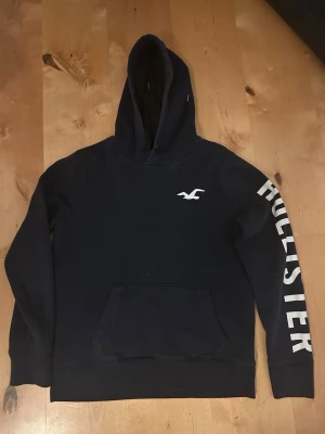 Hollister hoodie - Säljer denna blåa Hollister hoodie med snygga tryck. Storlek: S | Skick: ganska bra | Har du frågor eller funderingar hör gärna av dig🙌