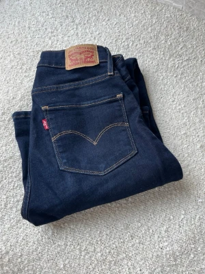 Mörkblå bootcut jeans från Levi's - Snygga mörkblå jeans från Levi's med bootcut form. Tillverkade i mjuk denim med stretch. Stl 25💕