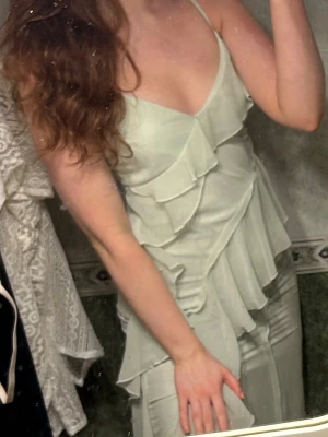 Klänning - ljus grön klänning från Gina Tricot, i bra skick. Slits vid låret, når ner till fötterna på mig som e 175 cm så den är lång.