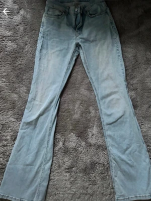 Ljusblå bootcut jeans från Perfect Jeans - Säljer ett par ljusblå bootcut jeans från Perfect Jeans i storlek 36. Jeansen har klassisk femficksmodell, dragkedja och knapp i midjan samt bälteshällor. Materialet är denim i bomull och passformen är utsvängd nedtill.