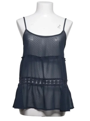 Hollister - Söt mörkblått linne från Hollisteri transparent mesh med tunna axelband och volangdetaljer. Prickigt mönster i tyget och dekorativ spets med blommor i midjan. Liten rosett bak. Perfekt för dig som gillar romantisk och luftig stil.