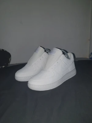 Nike Air Force 1 R3P - Klassiska helvita Nike Air Force 1 R3P sneakers i lågt utförande. Skorna har en stilren design med perforerade detaljer på tån, tydlig swoosh-logga på sidan. Kommer med emblem men inte snören