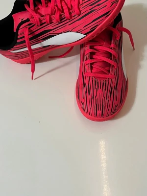 Inomhus fotbollsskor Puma - Snygga fotbollsskor från Puma. Skorna har ett mönster med svarta linjer och klassisk vit Puma-logga på sidan. De är tillverkade i syntetmaterial och har snörning för optimal passform. Storlek 39. Hör av dig vid frågor. 😁🌞