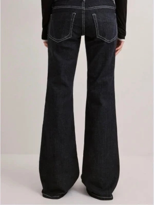 Mörkblå utsvängda jeans med vit sömn från Gina - Snygga mörkblå jeans med utsvängda ben och vita kontrastsö Benen är långa och modellen har klassiska fem fickor partially. Jeansen har hög midja och är tillverkade delvis i denim med stretch för extra sopassform.