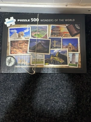 500-bitar pussel Wonders of the World - Säljer ett pussel med 500 bitar från Barnabas med temat Wonders of the World. Motivet visar kända sevärdheter som Machu Picchu, Colosseum och Taj Mahal i färgglada vykortsliknande bilder. Perfekt för dig som gillar utmanande pussel och resor.