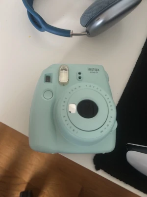 Instax Mini 9 mintgrön kamera - Säljer en Instax Mini 9 kamera från Fujifilm i mintgrön färg. Kameran har en kompakt och rund form, inbyggd blixt och 60mm lins. Perfekt för att ta instant-bilder och få dem direkt i handen. Materialet är plast och designen är modern och enkel. Har exakt en till den andra blev såld på Vinted, men säljer för 303 för att den förra 49 kr är väldigt lite för en Instax mini kamera dock också denna är icke använd. 😊