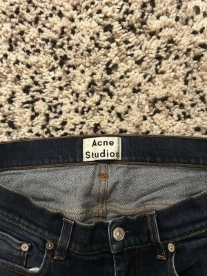 Mörkblå skinny jeans Acne Studios - Snygga mörkblå slim jeans från Acne studios.  Perfekta för en trendig och stilren look. Jeansen är storlek 32/34 men är väldigt små i storlek så sitter exakt som 30/32
