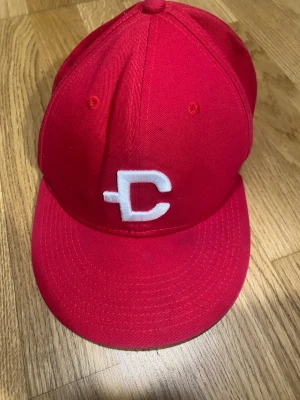 Röd keps från DjtCult med brodyr - Snygg röd keps från DjtCult med vit broderad logga på framsidan. Klassisk snapback-modell med platt skärm och justerbar baksida. Tillverkad i slitstarkt tyg och har detaljerade sömmar samt ventilationshål för extra komfort.