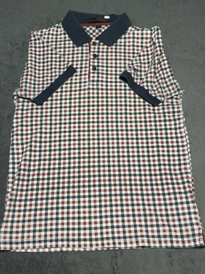 Ben Sherman Check Polo Shirt – Size S – Mod Style - Stilren piké från Ben Sherman i klassiskt rutigt mönster.  En ikonisk modell inspirerad av britisk mod-stil, med kontrastkrage och knappar framtill.  Perfekt till jeans eller chinos för en klassisk casual look.  Detaljer • Ben Sherman • Rutigt mönster (burgundy / navy / white) • Kontrastkrage • Kortärmad • Storlek S  📦 Skickas snabbt 💬 Hör av dig vid frågor