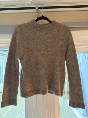 Beige stickad tröja från H&M - Säljer denna mysiga bruna stickad tröja från H&M i ull- och alpackablend.💕💕