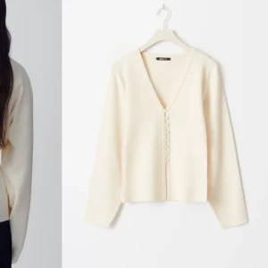 Vit kofta från Gina  - Säljer en stilren vit kofta från gina med v-ringning och knappar framtill. Koftan har långa ärmar och en mjuk, bekväm passform. Perfekt för lager-på-lager under kyligare dagar, och supersnygg nu till våren!🍂💕